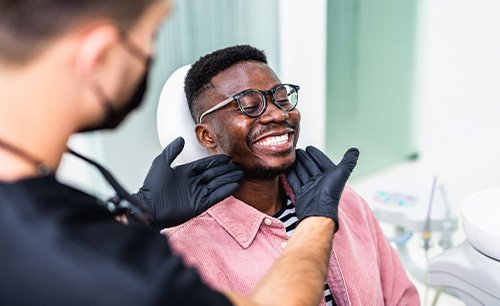 Dentist looking at patient's smile in treatment room