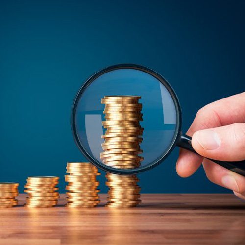 Stacks of coins measured by magnifying glass