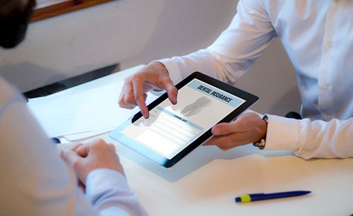 Patient reviewing dental insurance forms on tablet