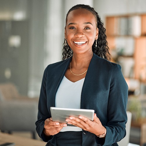 Woman smiling while holding tablet at work