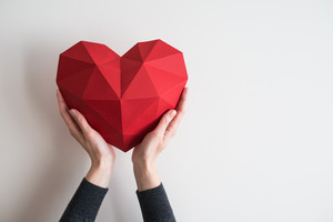 Hands holding a paper heart